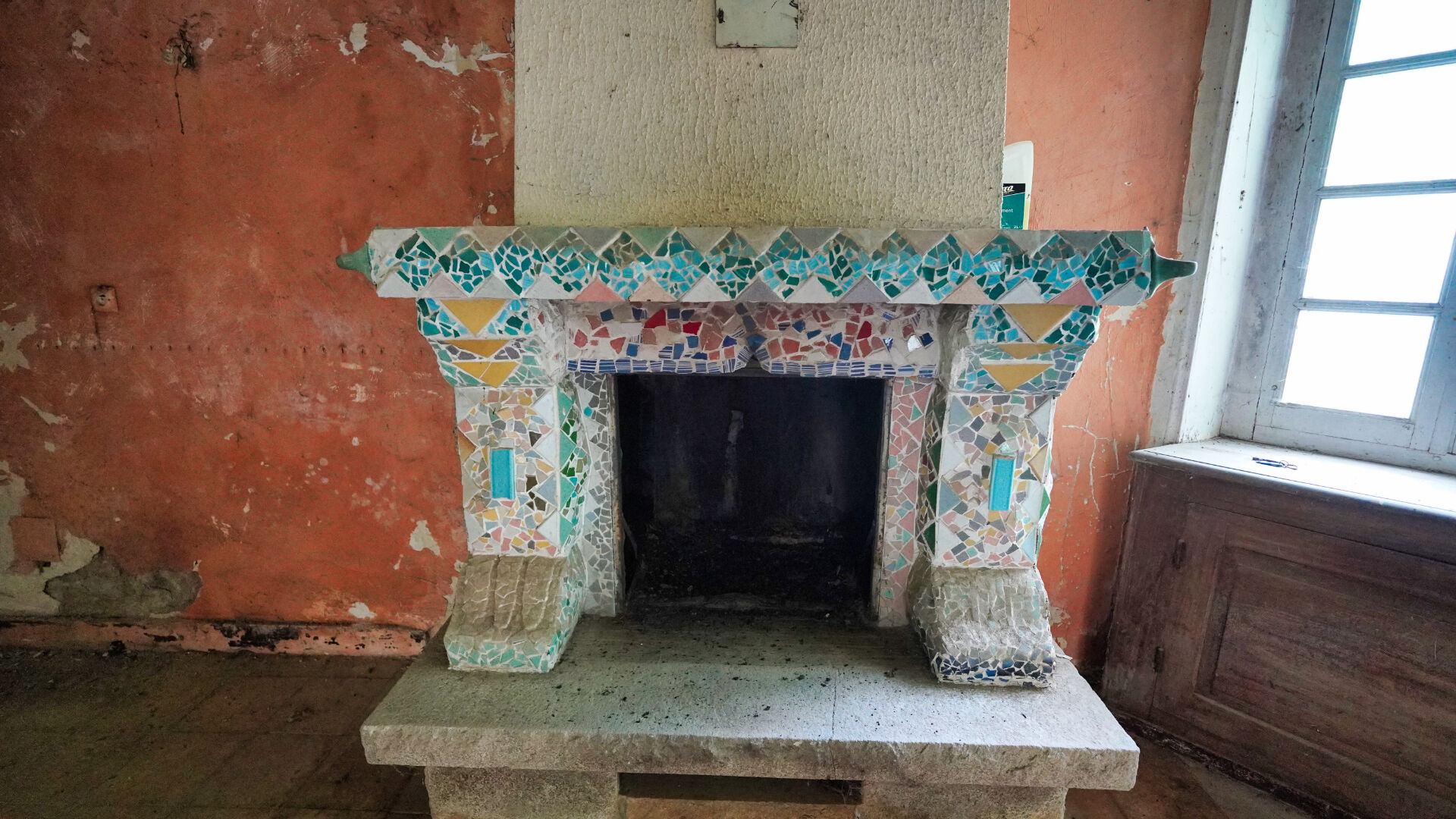 Five-bedroom property in Morbihan, Brittany, featuring a decorative tiled fireplace in a spacious interior.