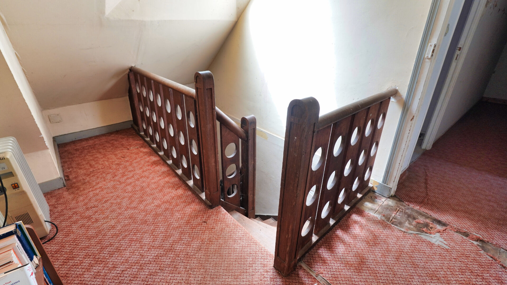 Staircase with wooden railing in a property located in Morbihan, Brittany, featuring a cosy interior design.