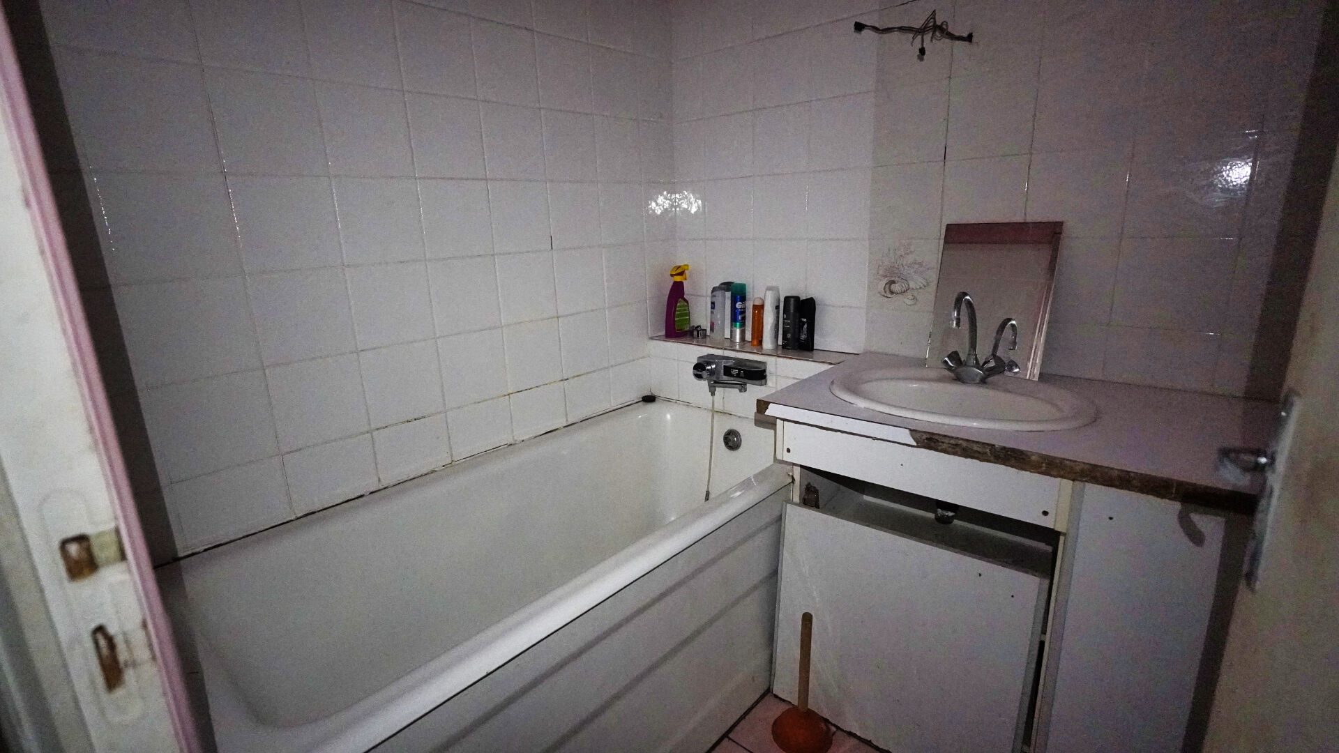 Bathroom featuring a bath, sink, and tiled walls in Morbihan, Brittany, 56200. Ideal for renovation in a spacious property.