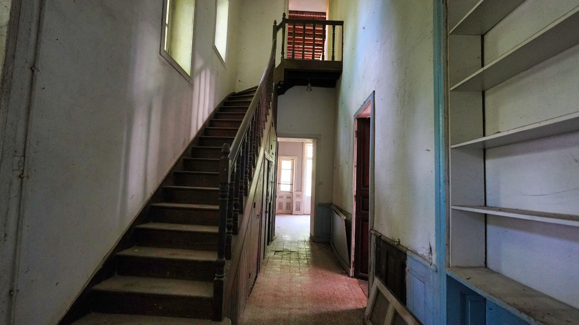 Spacious interior of a property in Morbihan, Brittany, featuring a staircase and ample natural light.