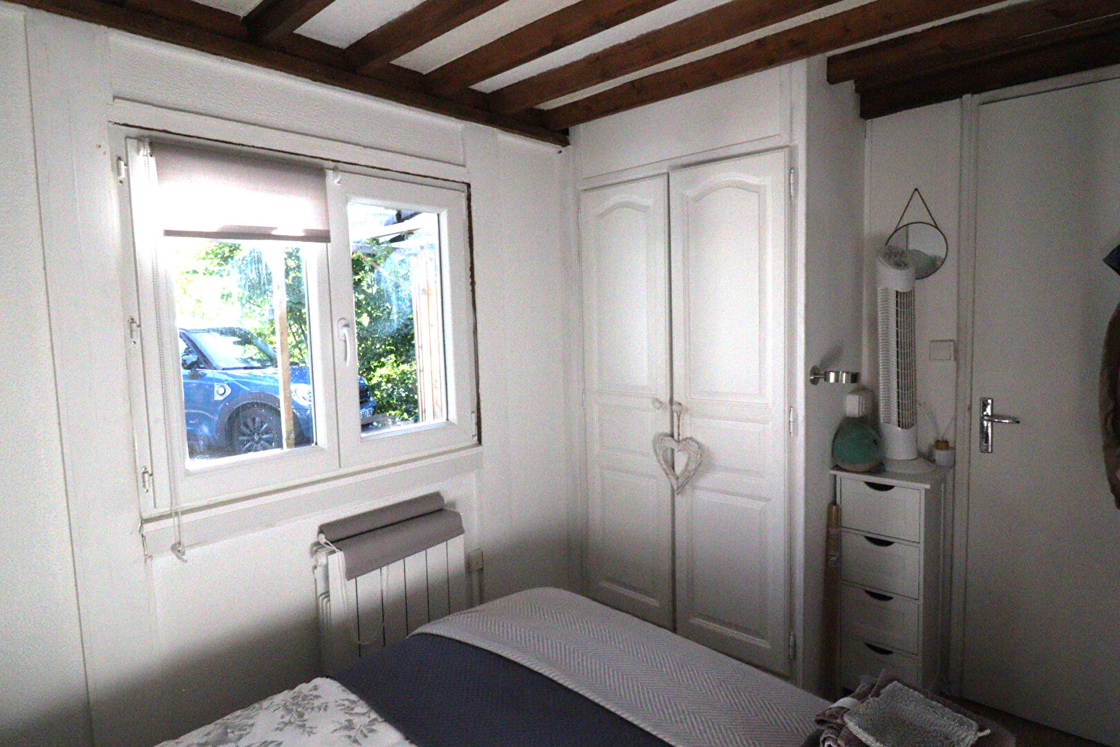 Bright interior of a property in Corrèze, Nouvelle-Aquitaine, featuring wooden beams and a cosy bedroom.