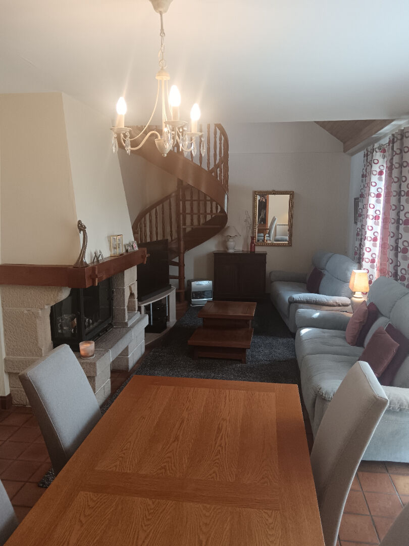 Spacious property in Manche, Normandy, featuring a living area with a fireplace and a spiral staircase.
