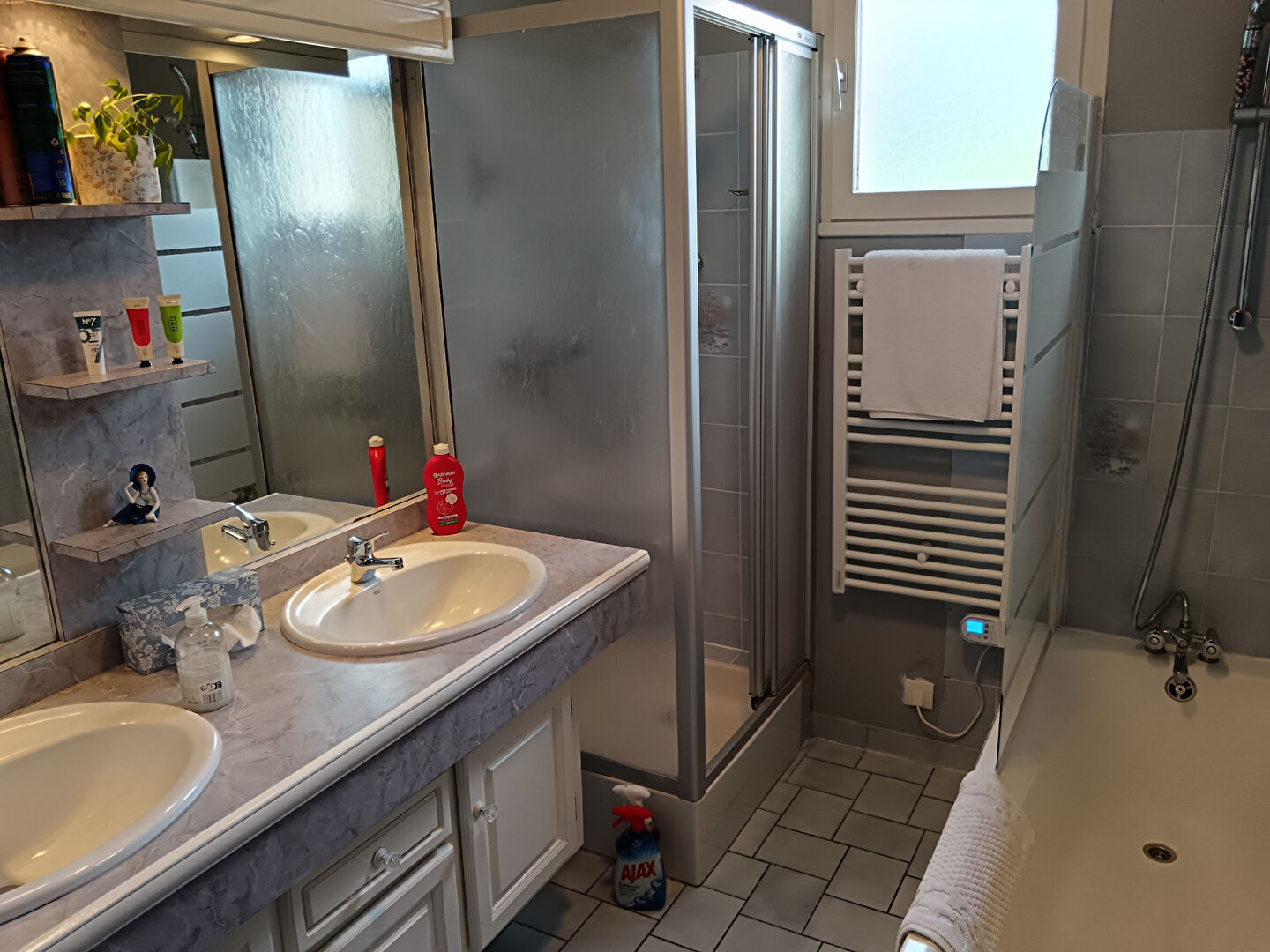Spacious bathroom with twin sinks, shower, and bath in property located in Manche, Normandy, postcode 50000.