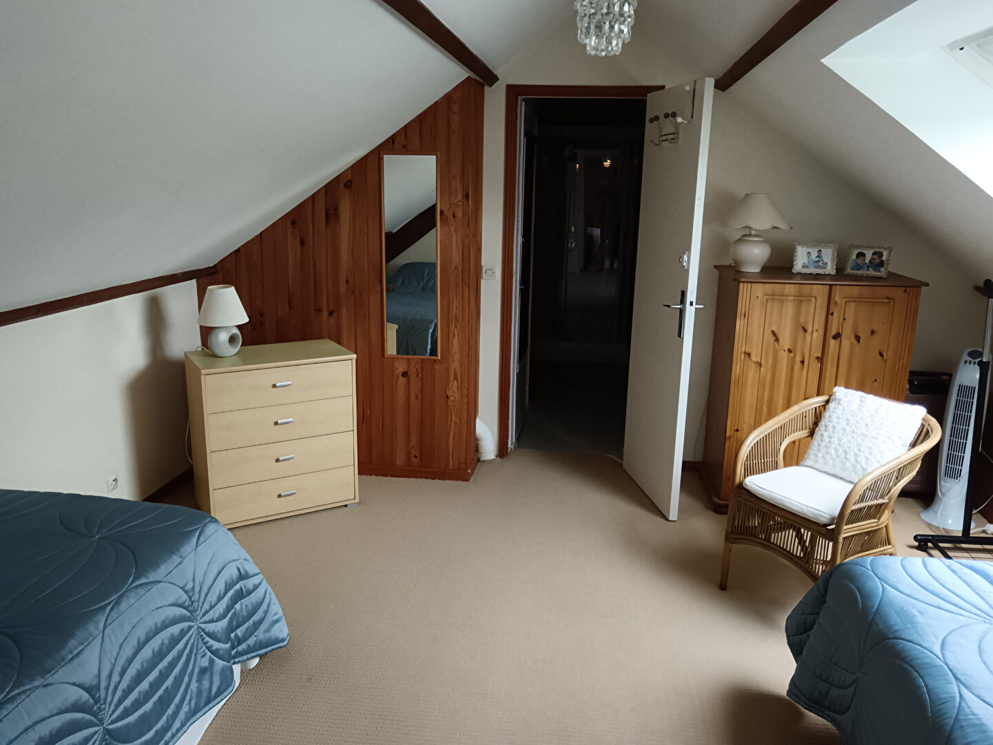Spacious property in Manche, Normandy, featuring two beds, a wardrobe, and a cosy seating area.
