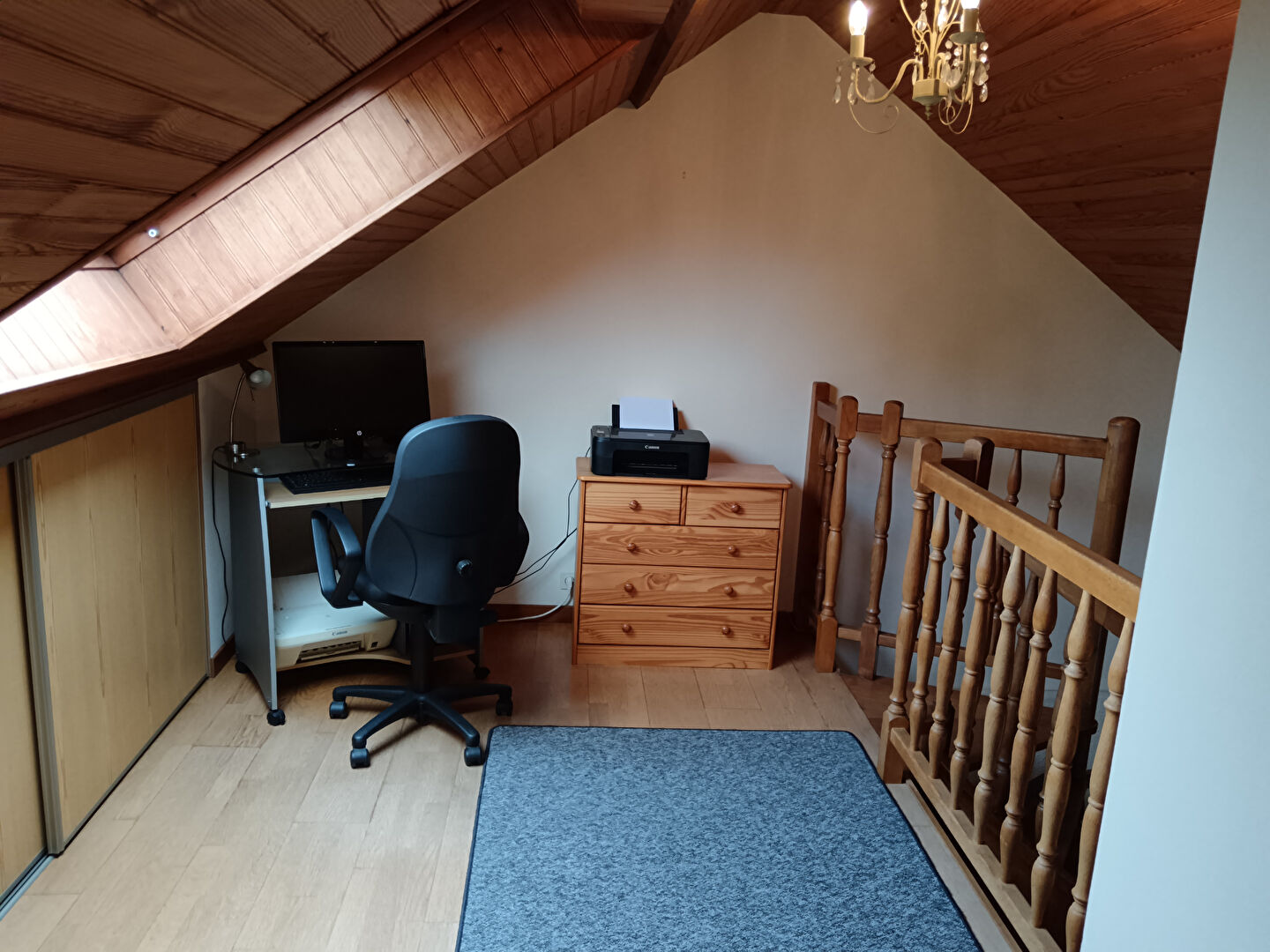 Spacious property in Manche, Normandy, featuring a loft area with desk, printer, and wooden accents.