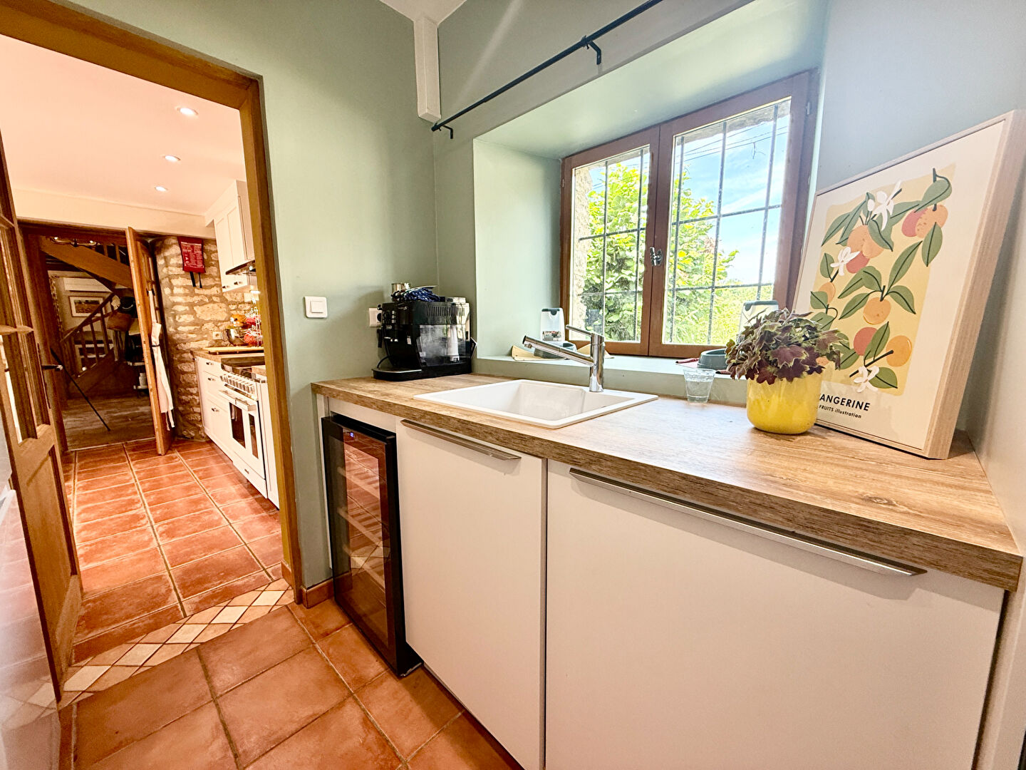 Modern kitchen with wooden countertop and views, located in Tarn-et-Garonne, Occitanie, featuring a swimming pool.