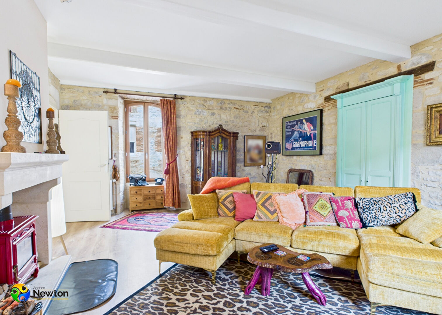 Charming property in Lot, Occitanie, featuring a cosy lounge with stone walls and a fireplace.