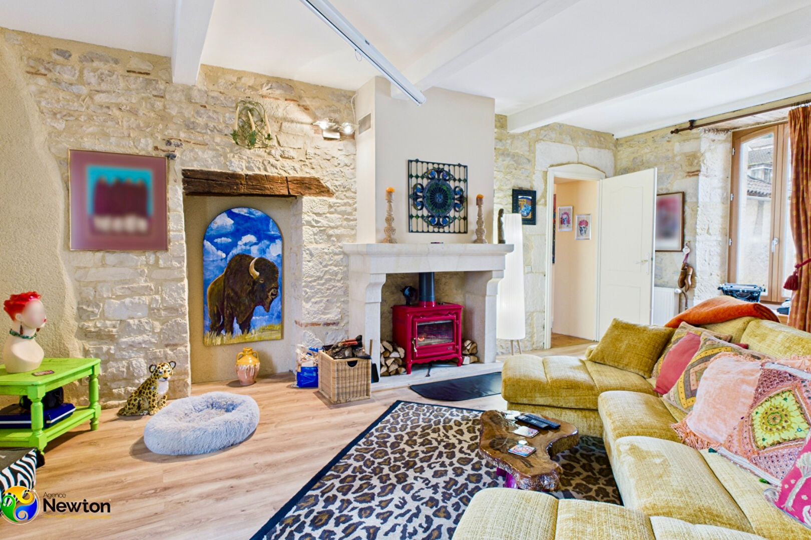 Spacious property in Lot, Occitanie, featuring a bright living area with a yellow sofa and stone walls.