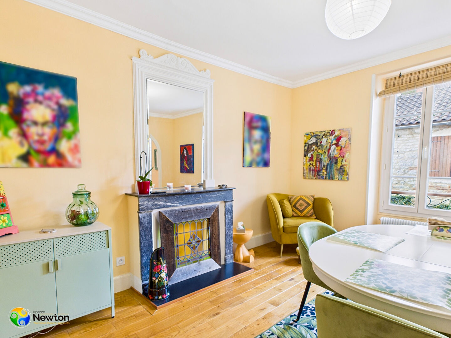 Bright living area featuring a decorative fireplace, art on walls, and a dining table in a property located in Lot, Occitanie