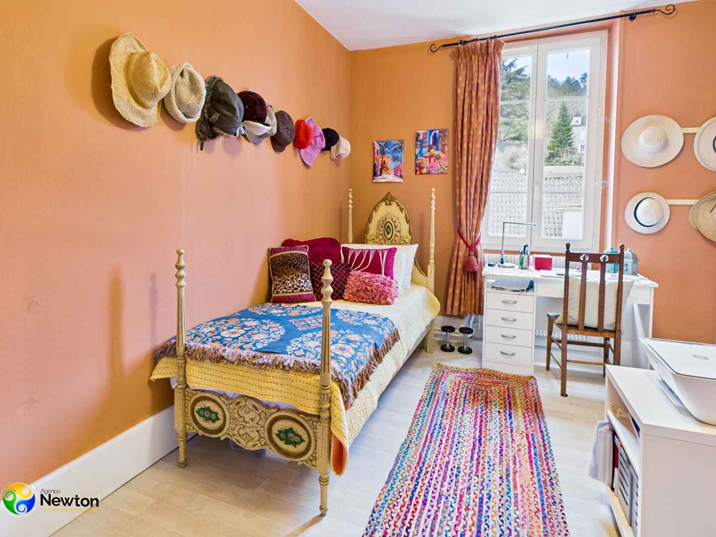 Bright bedroom featuring a vibrant bedspread, window view, and decorative elements in Lot, Occitanie.