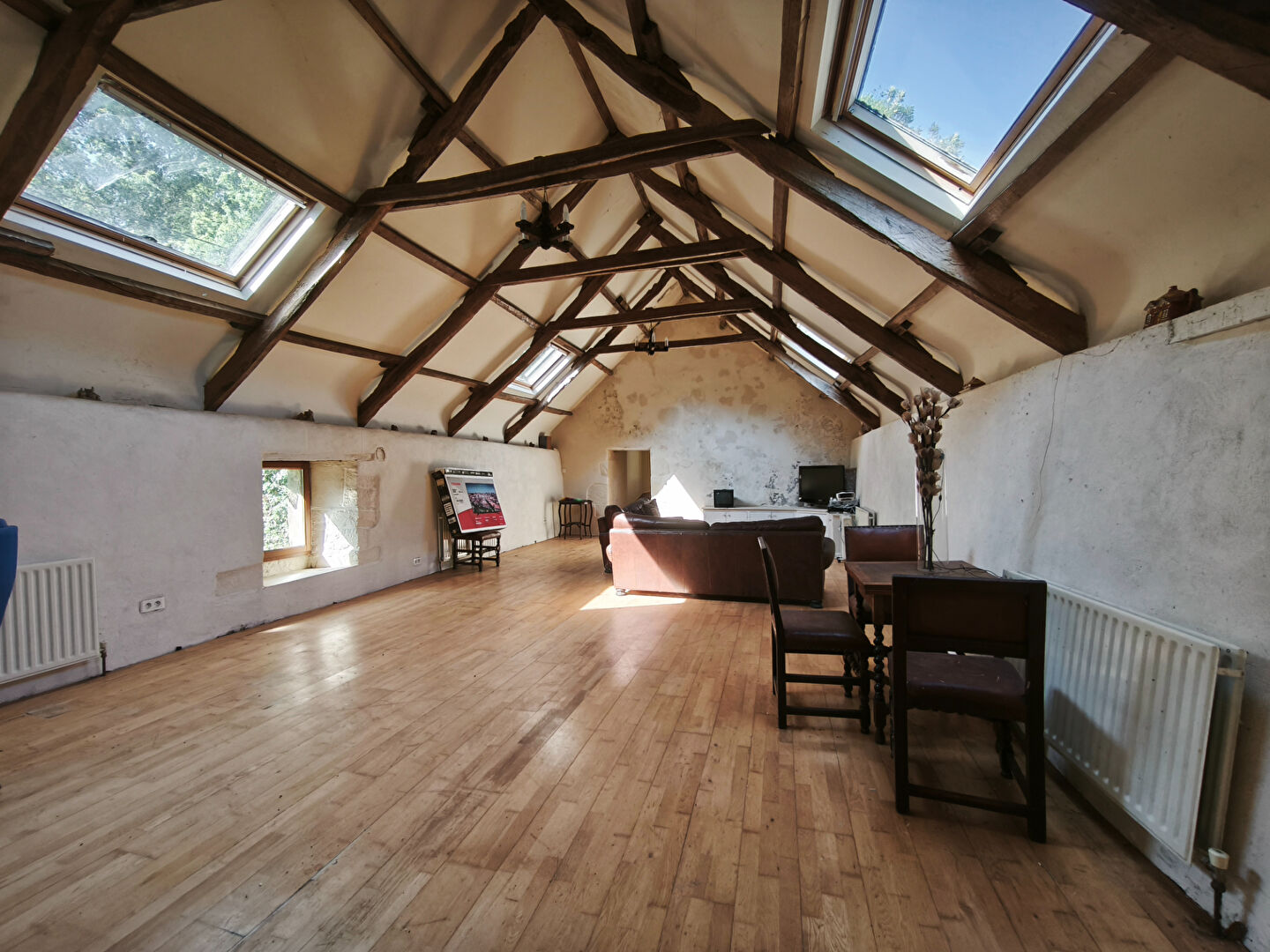 Spacious property in Morbihan, Brittany, featuring high ceilings, skylights, and wooden flooring in an open-plan living area.