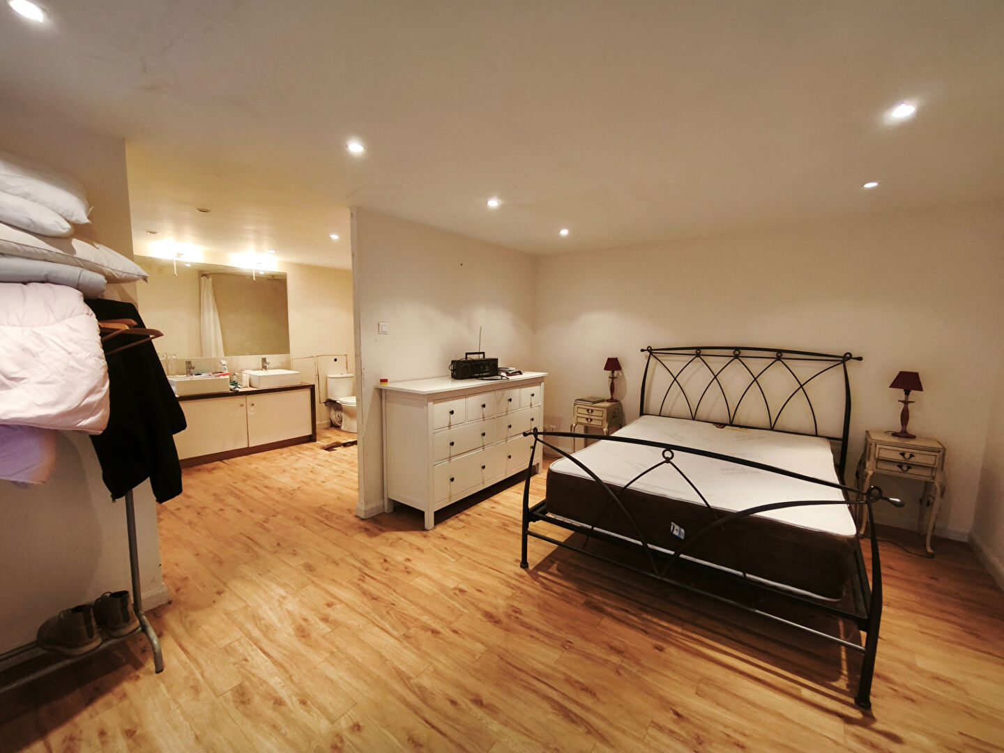 Spacious property in Morbihan, Brittany, featuring a well-lit bedroom with wooden flooring and modern furnishings.