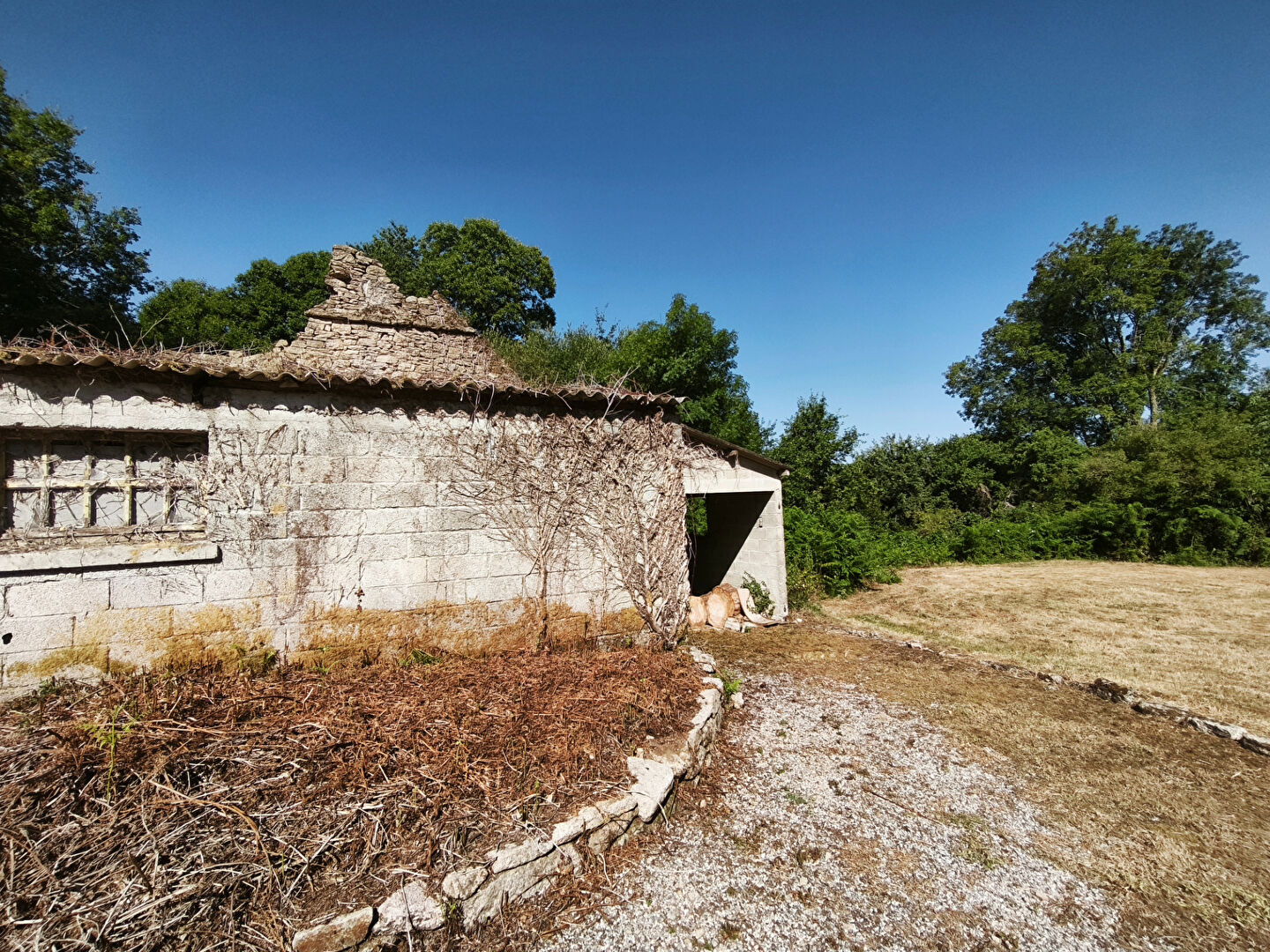 Renovation opportunity in Morbihan, Brittany, featuring a stone property surrounded by greenery and open space.