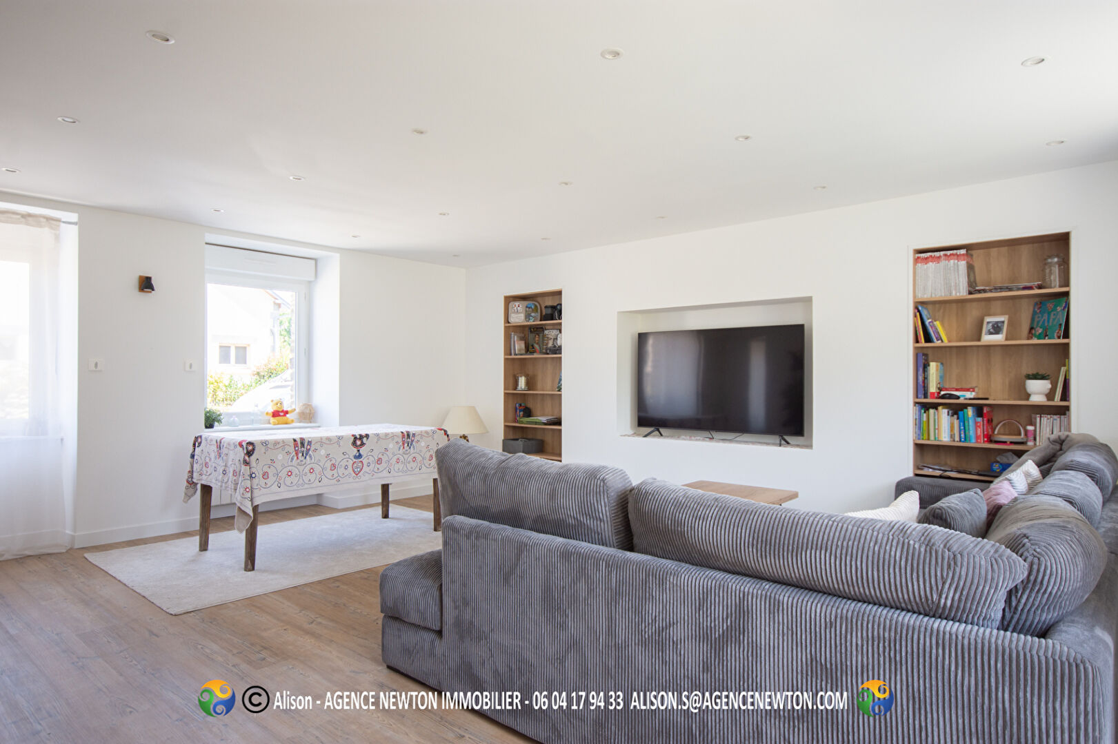 Spacious property in Manche, Normandy, featuring a bright living area with modern furnishings and a large TV.