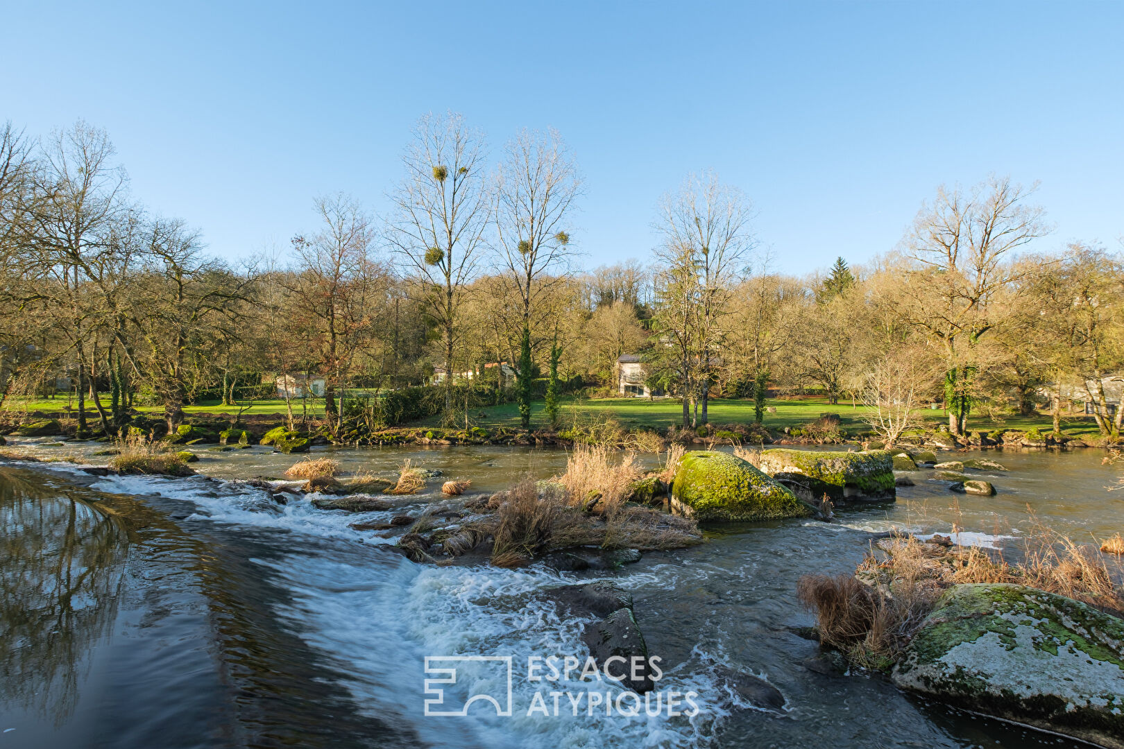 Moulin au bord de l'eau avec piscine à proximité d'un village