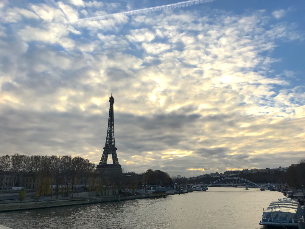 Eiffel Tower view over the Seine in Paris, Île-de-France, showcasing cityscape and riverfront.