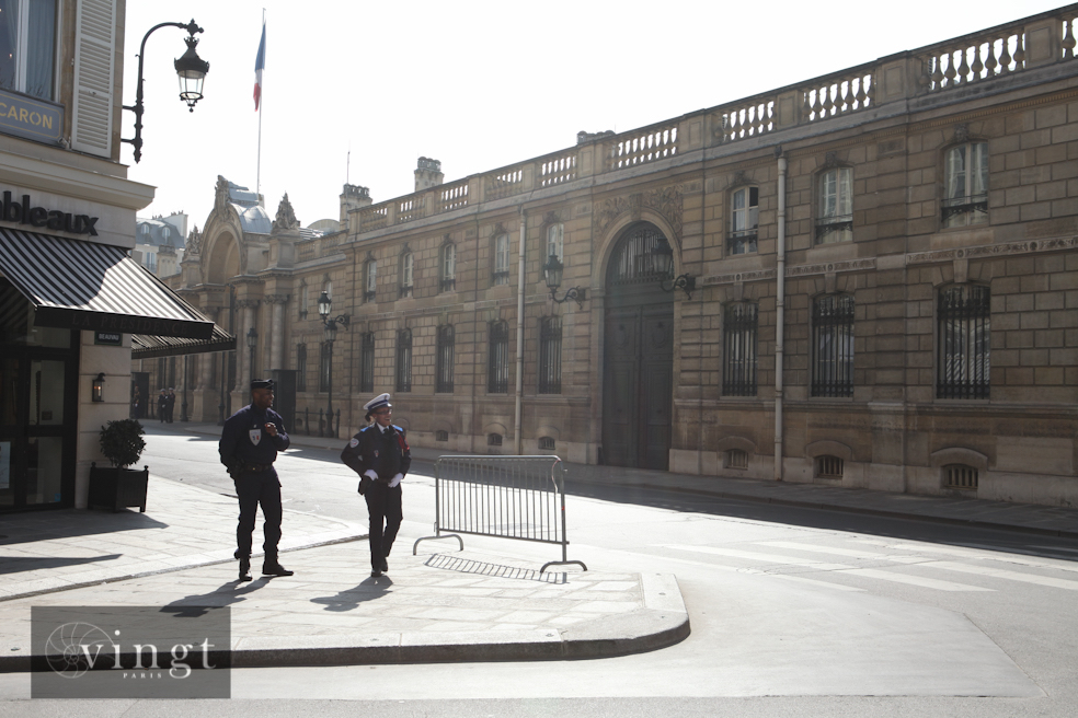 Two police officers standing outside a historic building in Paris, Île-de-France, 75008.
