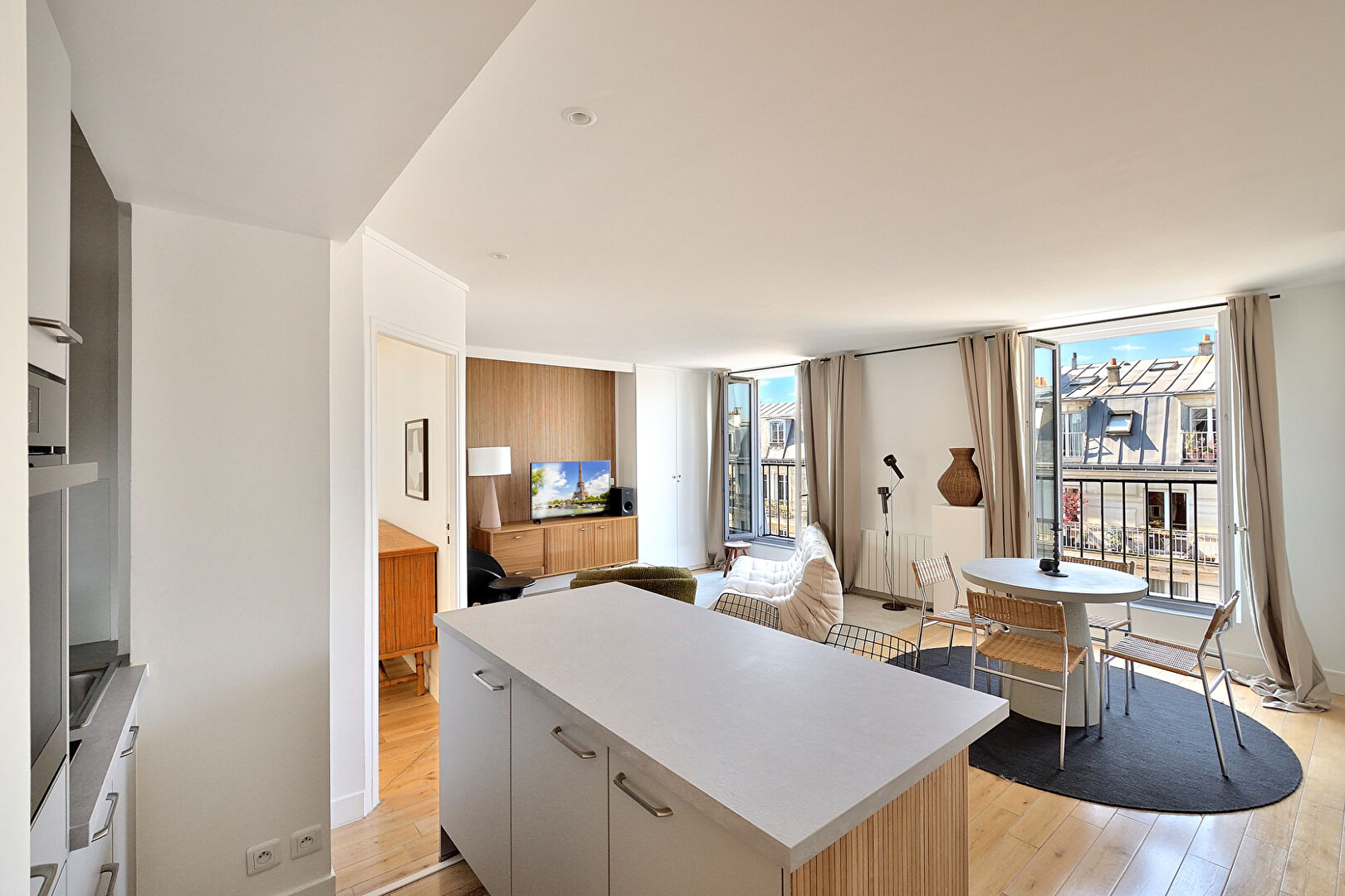 Bright apartment in Paris, Île-de-France, featuring modern furnishings and large windows with city views.